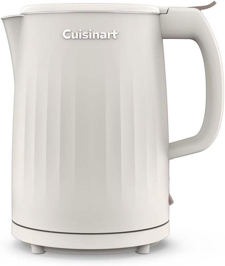 A Cuisinart electric kettle in a warm off-white or cream color, featuring a ribbed vertical design on the body, a matching lid, and a curved handle, shown against a plain white background.