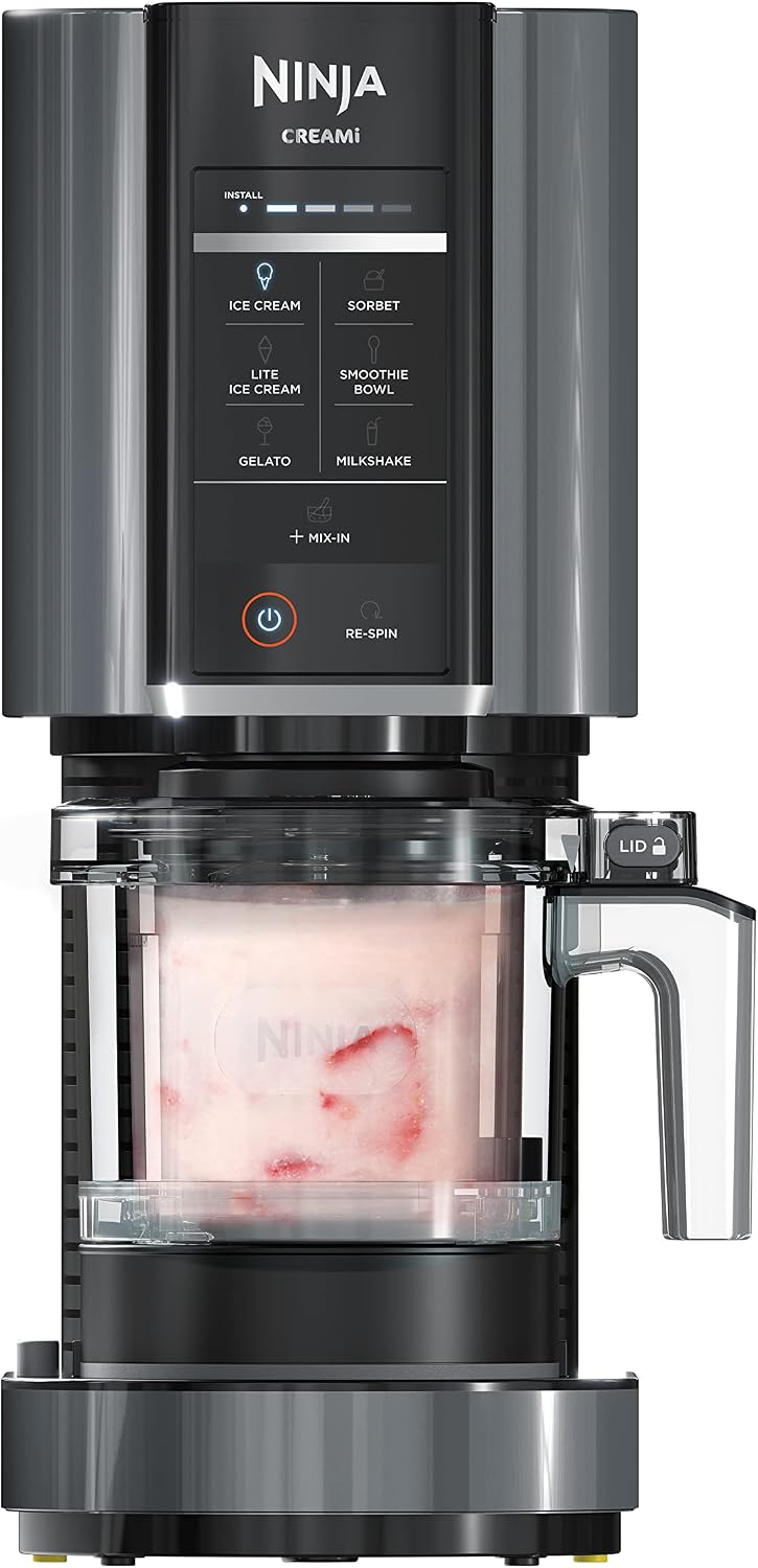Ninja creami ice cream maker with clear container showing ice cream on a white background