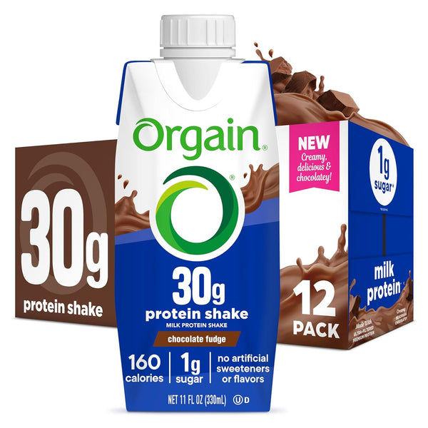 Orgain 30g protein shake milk protein shake chocolate fudge flavor, shown as an 11 fl oz carton centered in front of a 12-pack box. The packaging is white and blue with green and orange accents, and chocolate splash graphics.